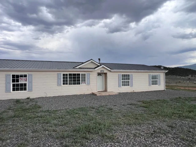 Siding exterior with a metal roof and decorative shutters