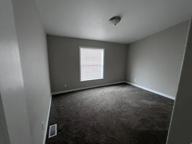 Neutral wall finishes, dark carpet, and window blinds