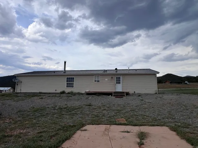 Beige horizontal siding exterior with a dark metal roof