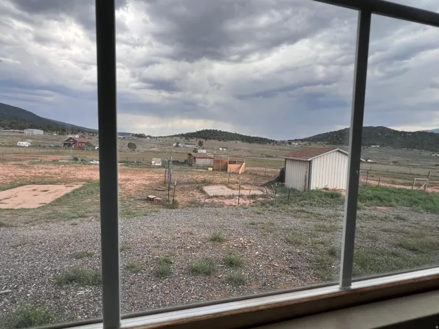 Mountain backdrop with distant structures and open land