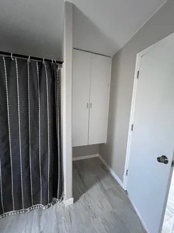 Recessed built-in cabinetry, tile flooring, and a solid core door
