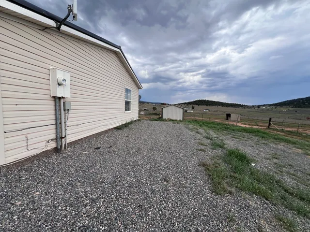 Siding exterior with a single window and gravel landscaping