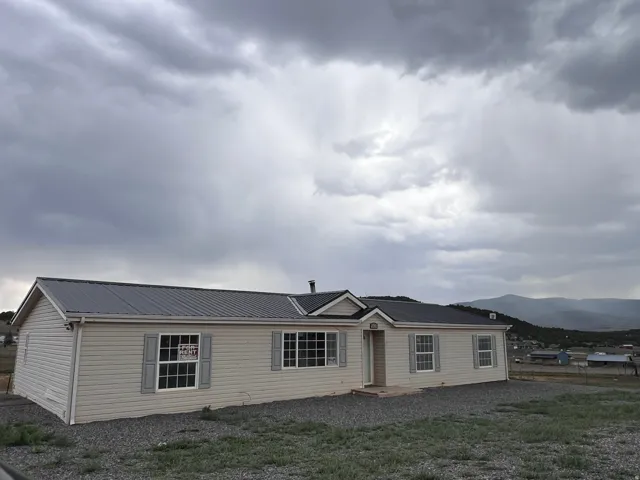 Light-colored vinyl siding exterior with gray metal roofing