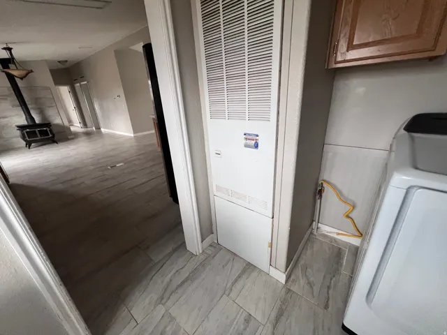 Ceramic tile flooring, built-in wood-burning stove, and overhead lighting fixture