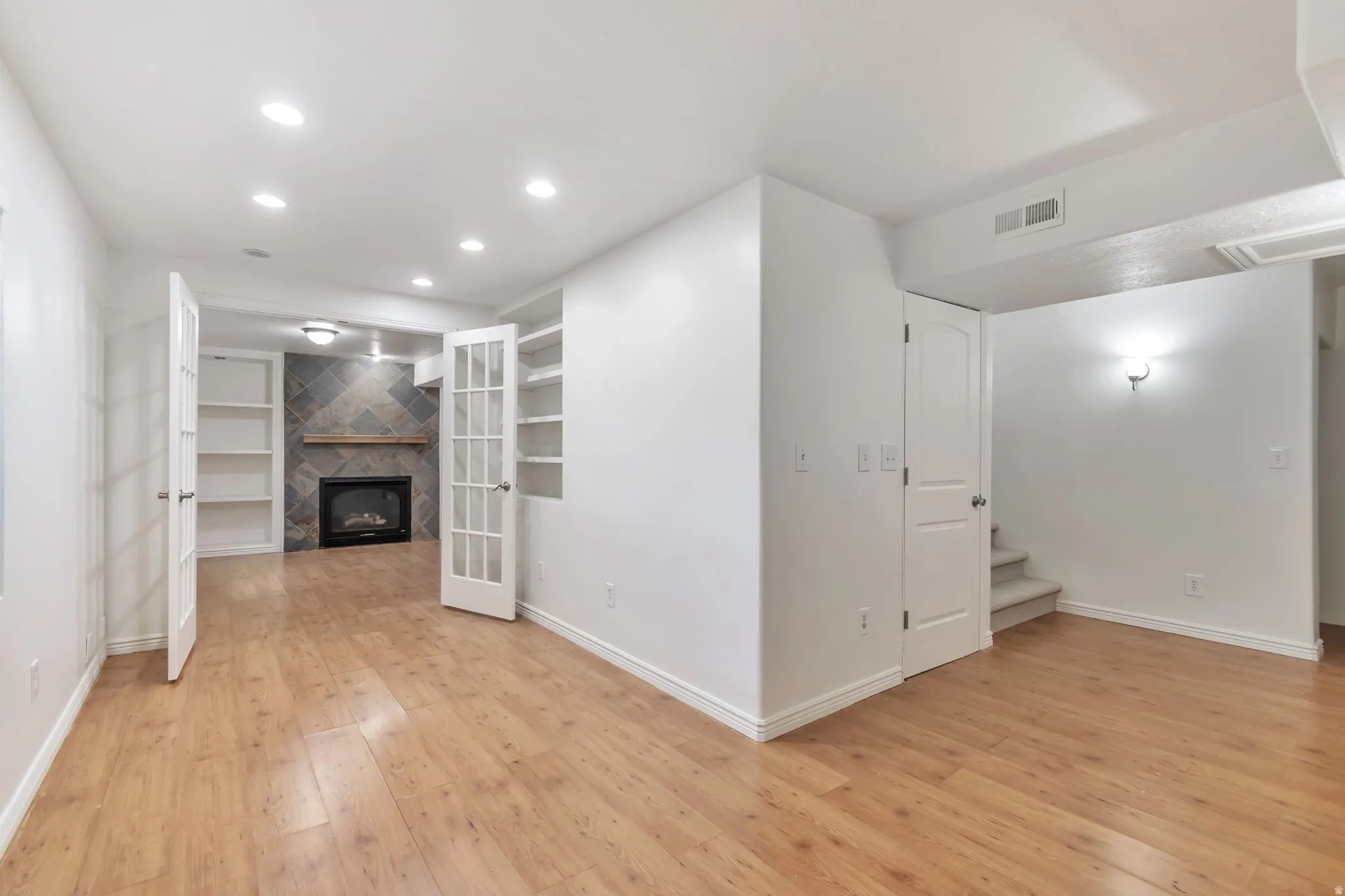 Recessed lighting illuminates wood-finish flooring