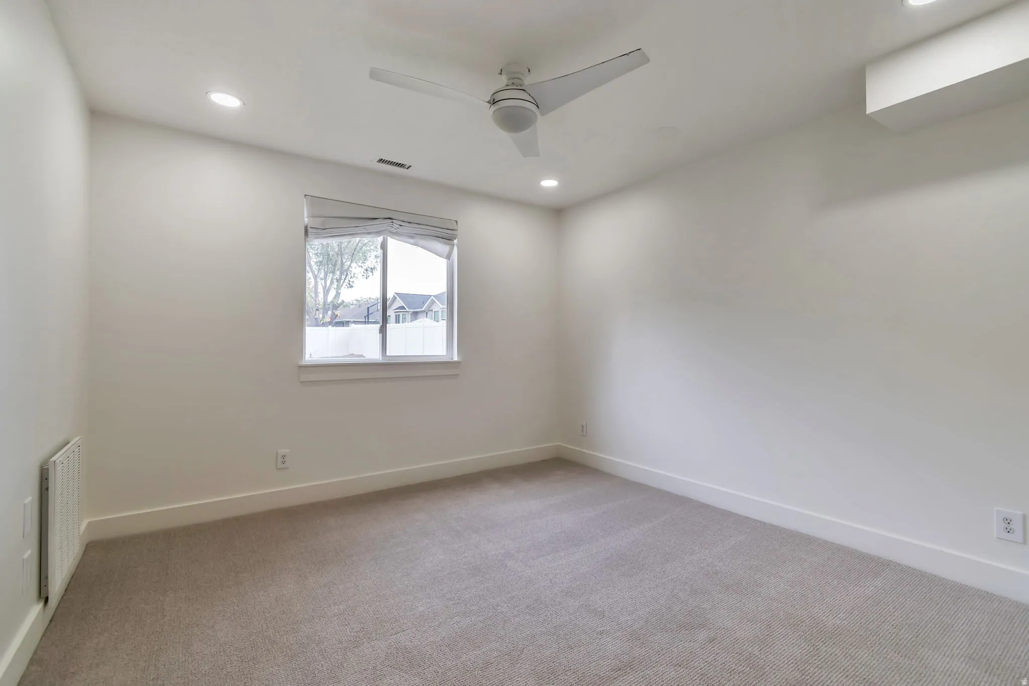Recessed ceiling lighting, ceiling fan, carpet flooring, window with blinds, and white walls