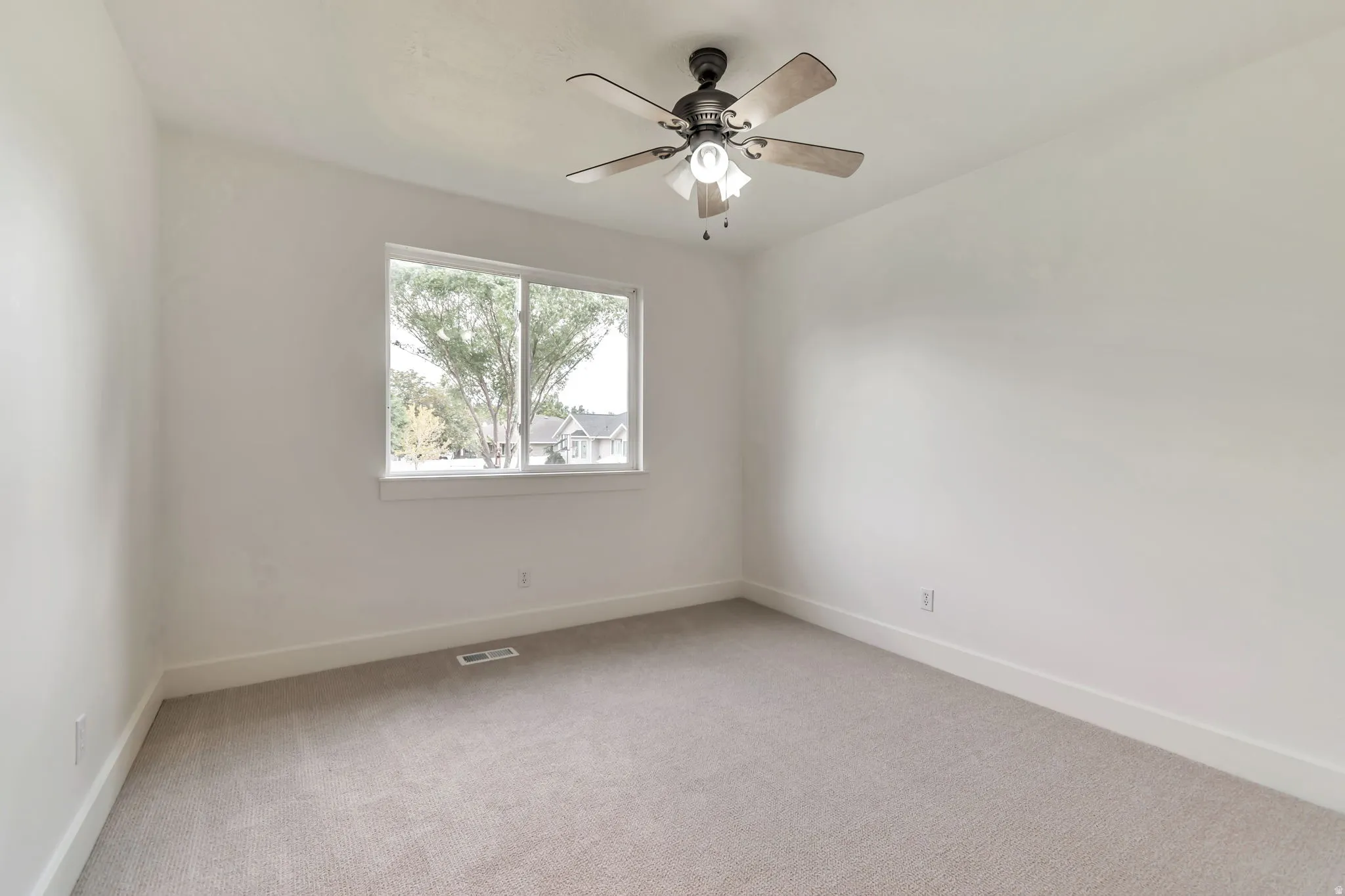 Neutral wall color, ceiling fan with light fixture, double-pane window, light-toned carpeting, and white trim