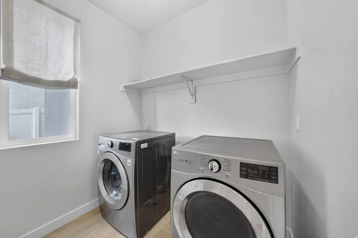 Hard surface flooring, neutral wall tones, and built-in shelving, next to garage entrance.