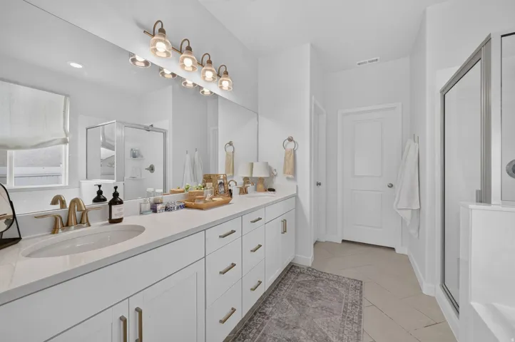 Dual vanity with integrated sinks, quartz countertop, and brushed brass fixtures