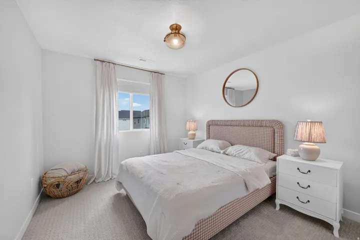 Carpeted flooring, a window with curtain rod and drapes, and a central ceiling light fixture
