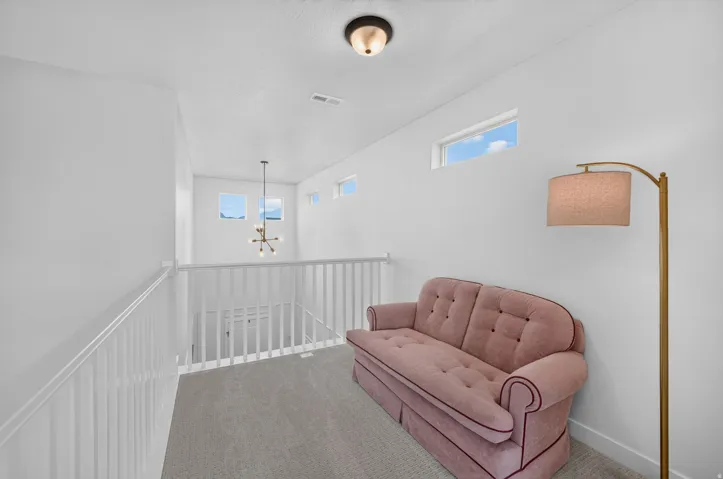 Bright secondary bedroom or nursery featuring white painted walls, recessed ceiling lighting, and multiple transom windows providing natural light