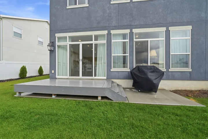Expansive outdoor decking with steps, complemented by a concrete patio