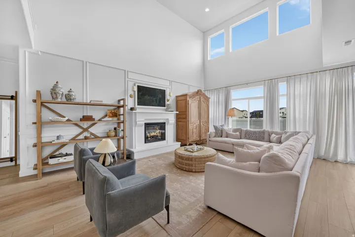 Vaulted ceilings, wood-finish flooring, custom millwork, built-in fireplace, and expansive windows