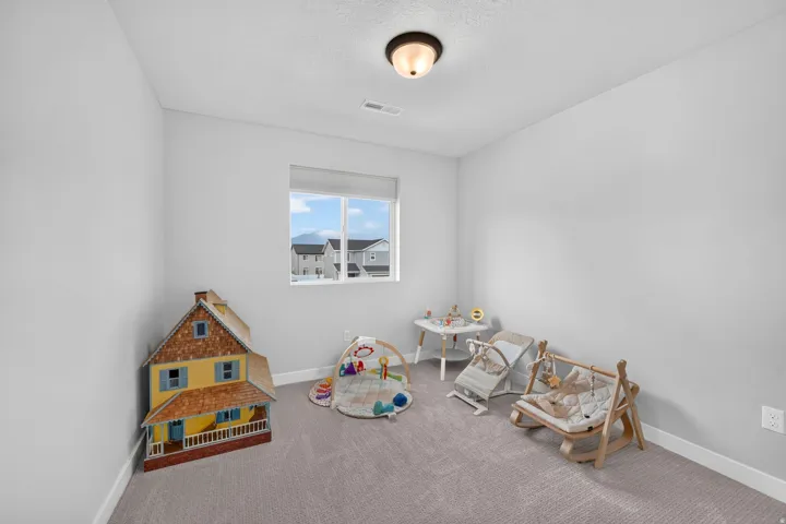 Light gray wall paint, recessed window with white trim, gray carpeted flooring, and a flush mount ceiling light