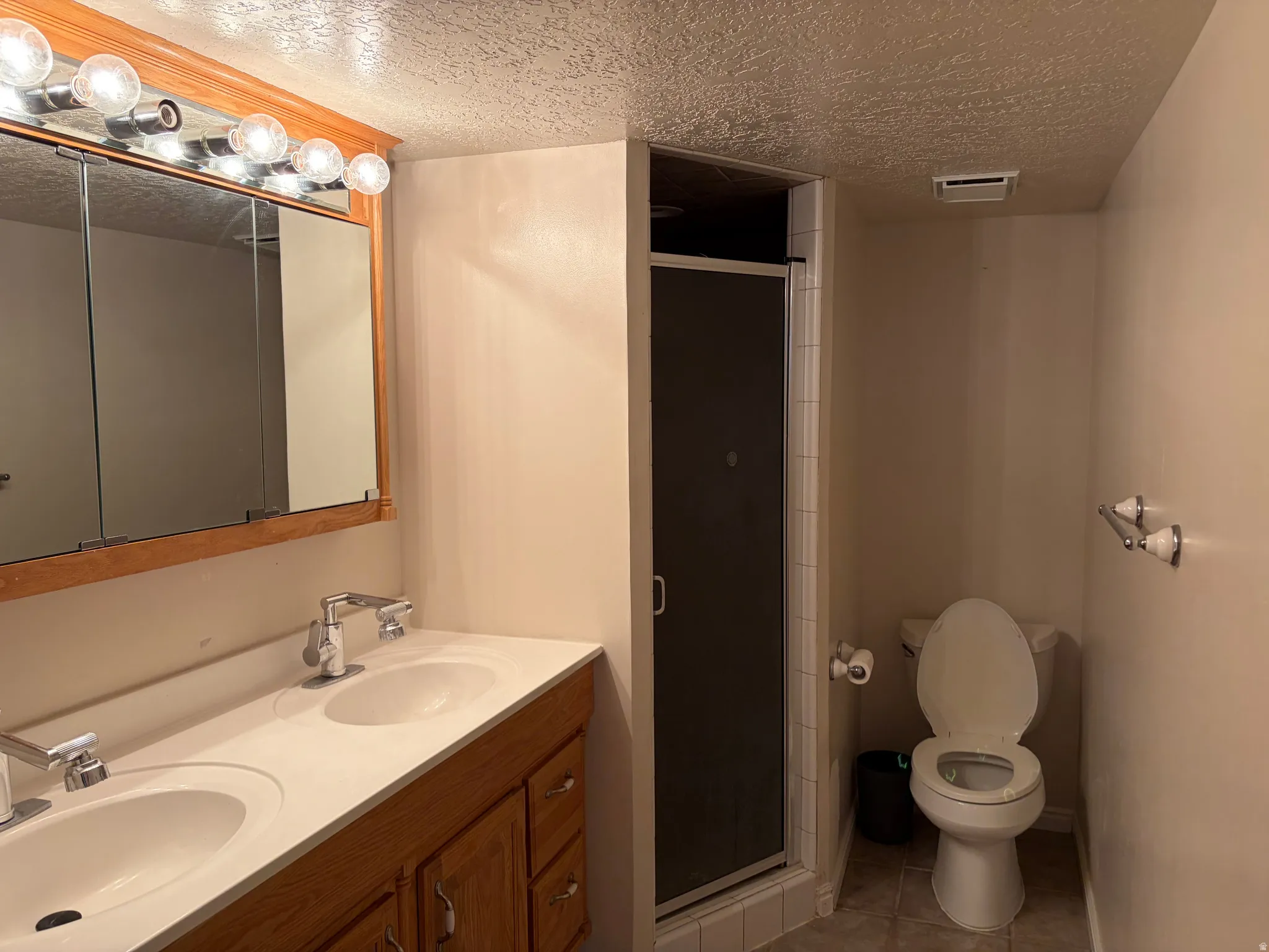 Double vanity with dual undermount sinks, wood-finish cabinetry, and a chrome faucet set