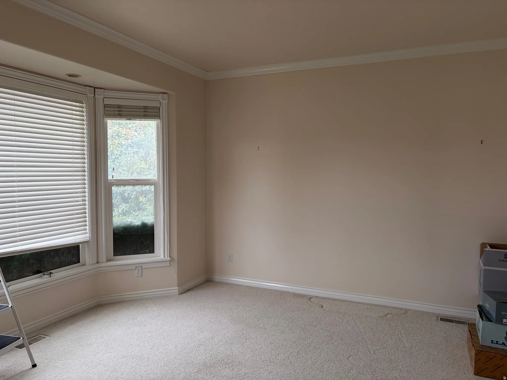 Bay window with multiple panes, recessed lighting, and crown molding