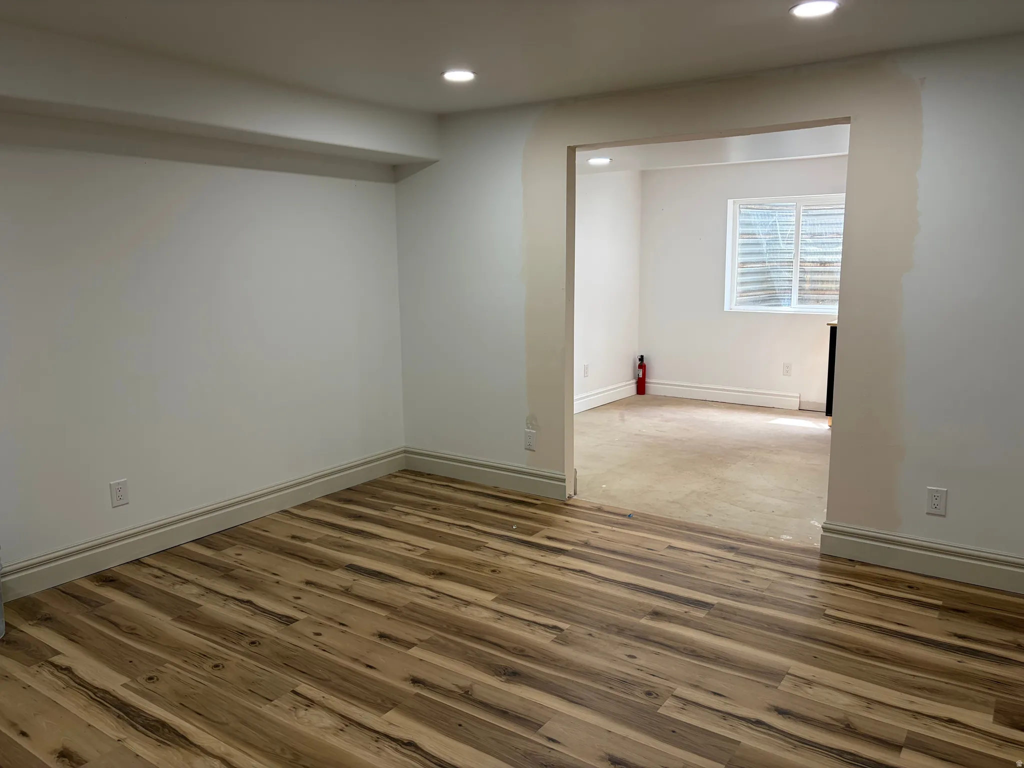 Wood-finish flooring, recessed lighting, and white baseboards