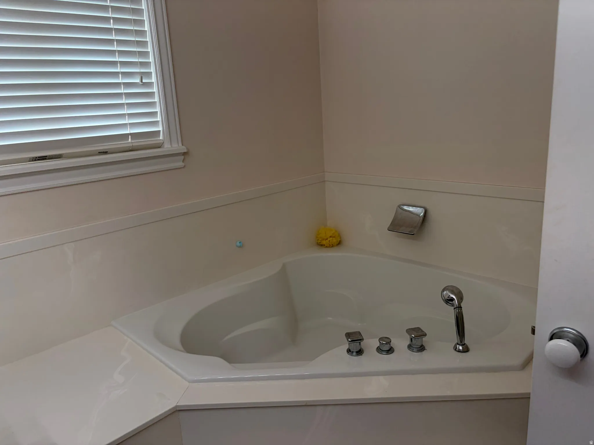 Corner soaking tub with integrated shower wand and four-piece faucet set
