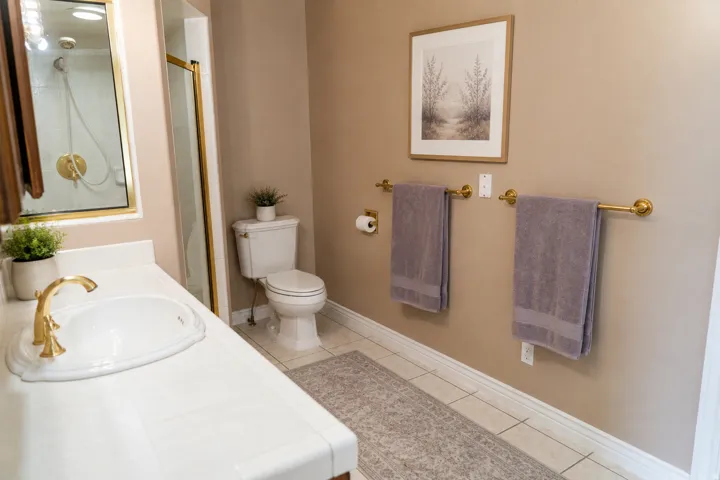 White vanity with integrated sink and gold-finish faucet