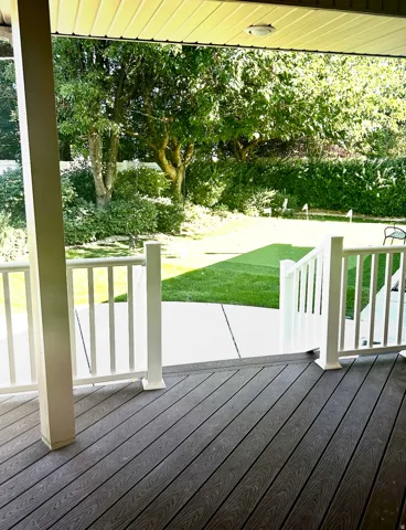 Covered porch with composite decking and white railings