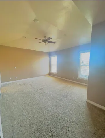Expansive room featuring vaulted ceilings, recessed lighting, a ceiling fan, and carpeted flooring