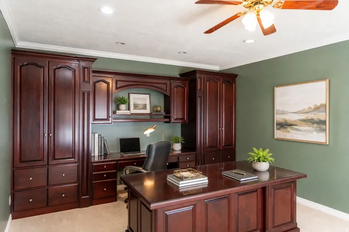 Built-in cabinetry with rich wood-finish, integrated desk space, recessed lighting, and a ceiling fan with light fixture