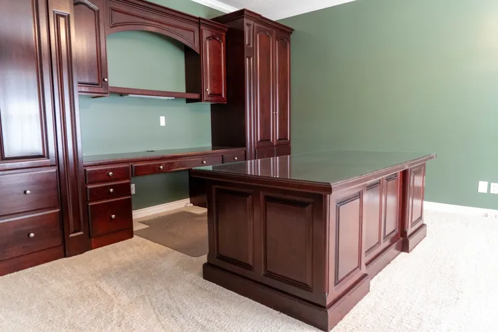Built-in cabinetry with rich wood finish, integrated desk, and coordinating central desk