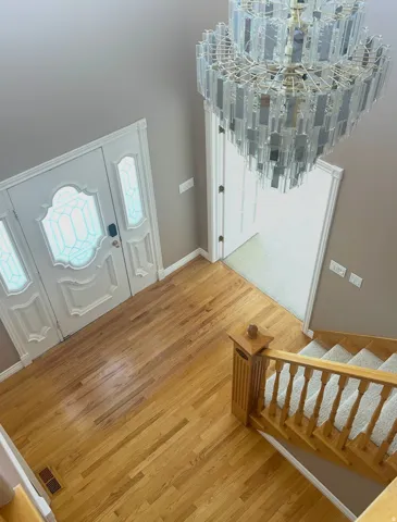 Hardwood flooring and a decorative front entry door with sidelights