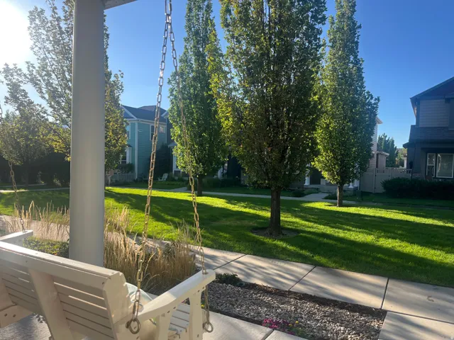Front porch with a white porch swing, chain suspension, and a column support