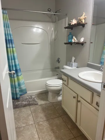 White tub and shower combination with a showerhead and separate handheld sprayer