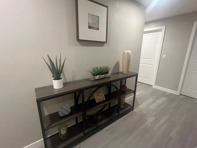 Gray wood-finish flooring with light gray walls, white trim, and white two-panel interior doors