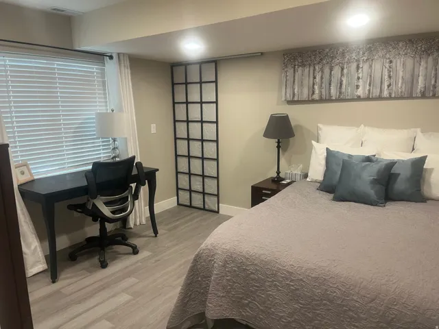 Light wood-finish flooring, recessed lighting, and a window with blinds and drapes