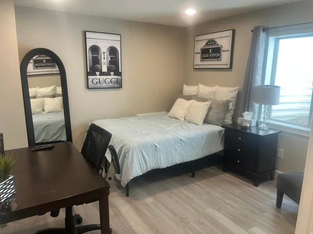 Wood-finish flooring, recessed lighting, and a window with curtain rod and drapes