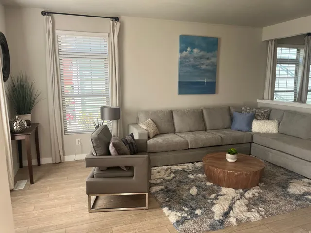 Light neutral wall paint, wood-look plank flooring, and a large window with blinds