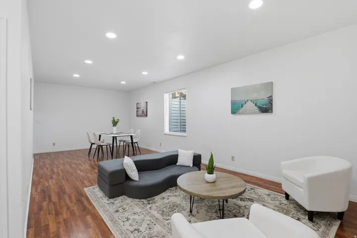 Recessed lighting illuminates wood-finish flooring throughout