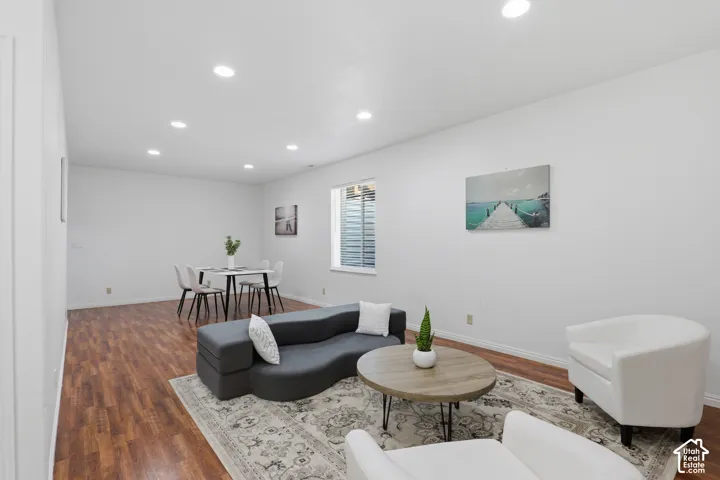 Recessed lighting illuminates wood-finish flooring throughout