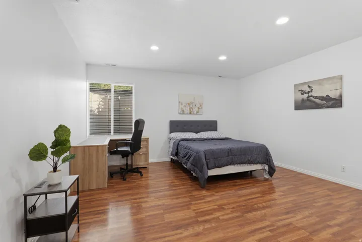Recessed lighting, wood-finish flooring, and a window with blinds