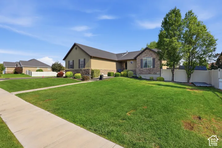 Exterior featuring neutral-toned stucco, stone veneer accents, and dark shingle roofing