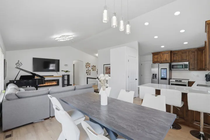Open-concept living space featuring wood-finish flooring, recessed lighting, and vaulted ceilings