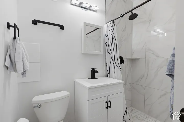 White vanity with black hardware, black faucet, and white countertop