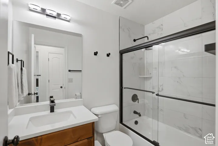 Modern vanity with wood-finish cabinetry, white countertop, and matte black fixtures