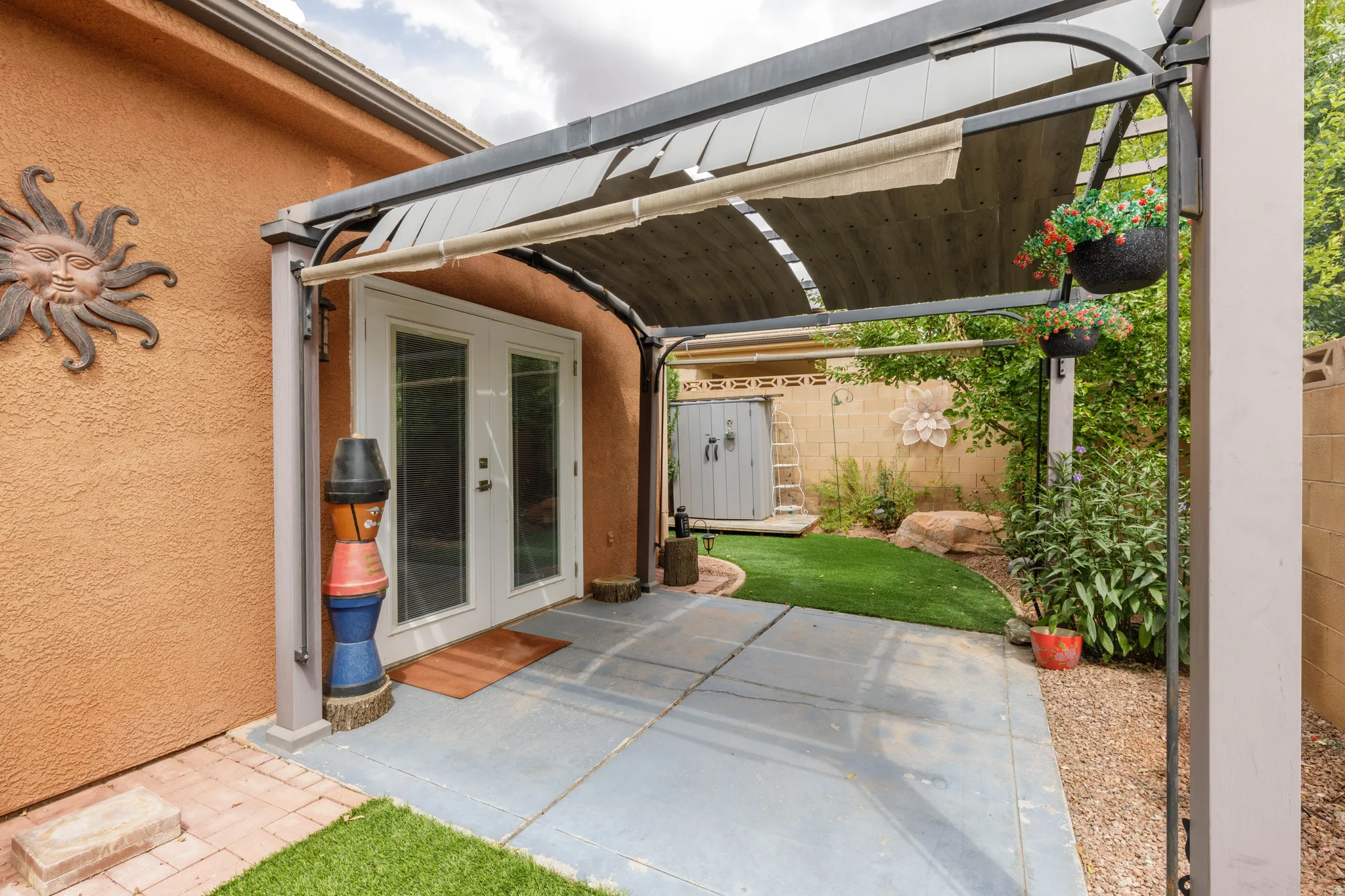Covered patio with a retractable shade canopy and dual glass panel doors
