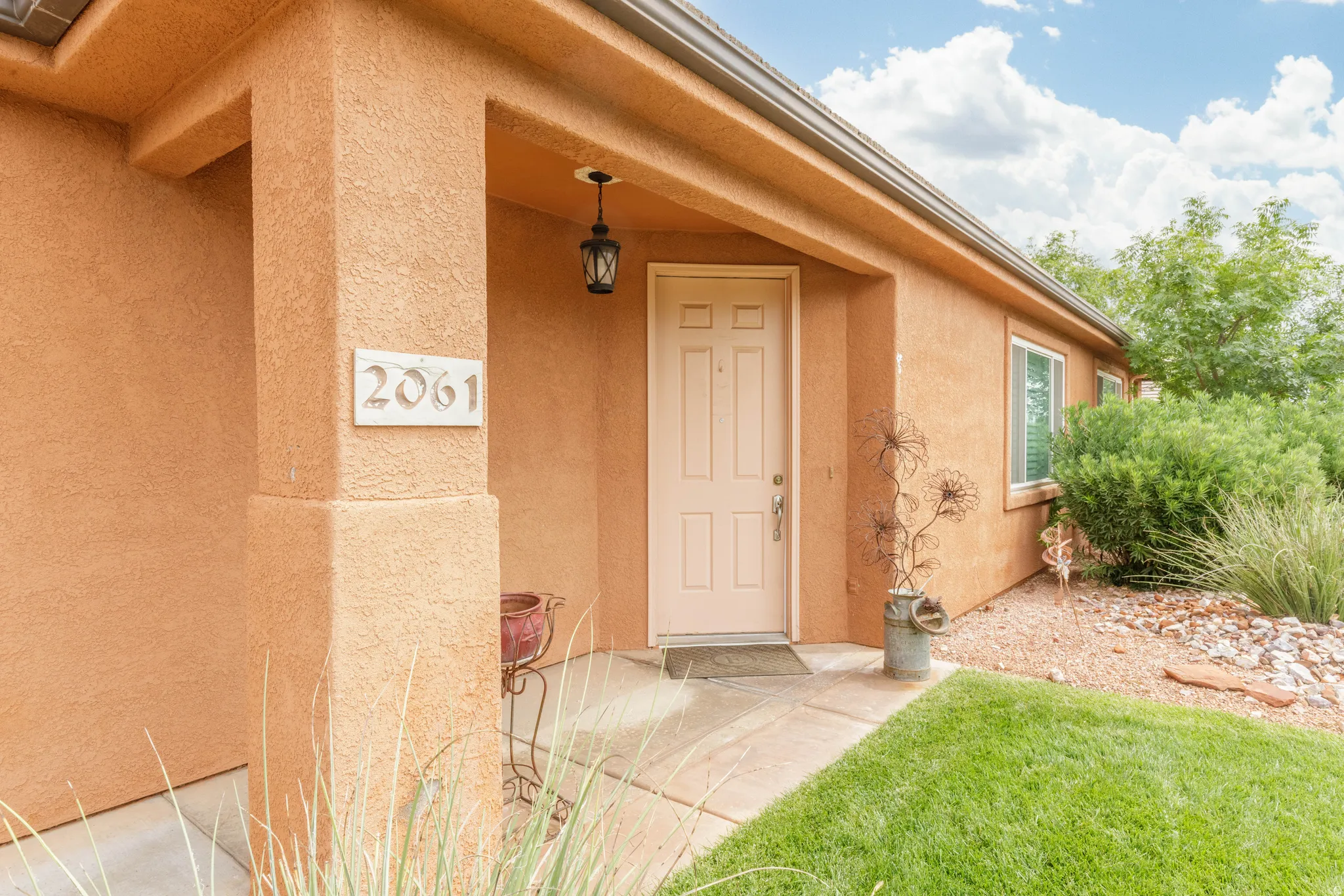 Stucco exterior featuring a covered entry and concrete walkway