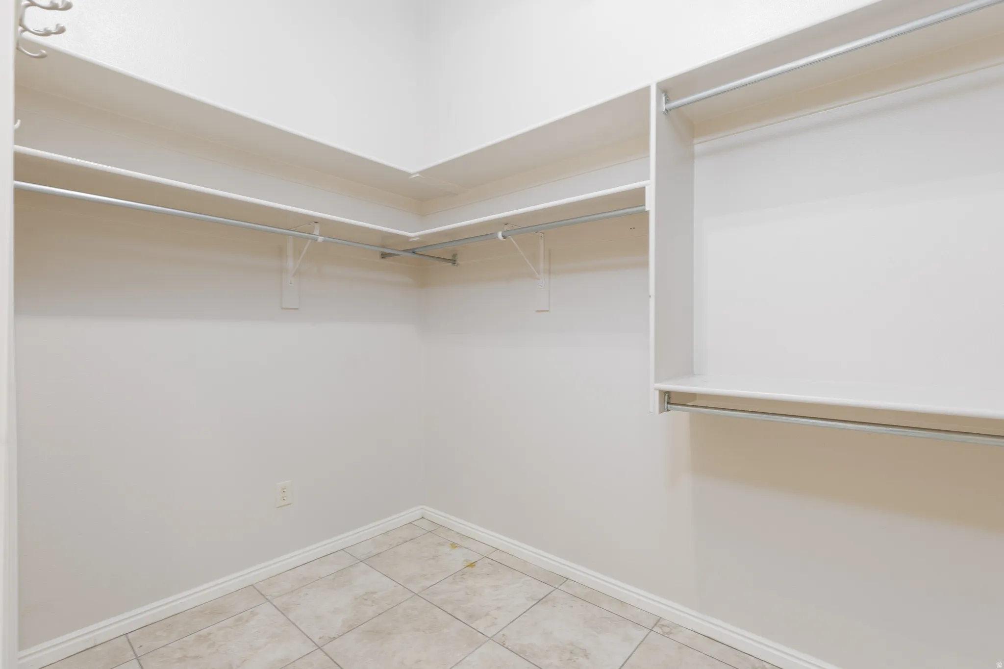 Built-in shelving and hanging rods, light-toned tiled flooring, and light wall finishes