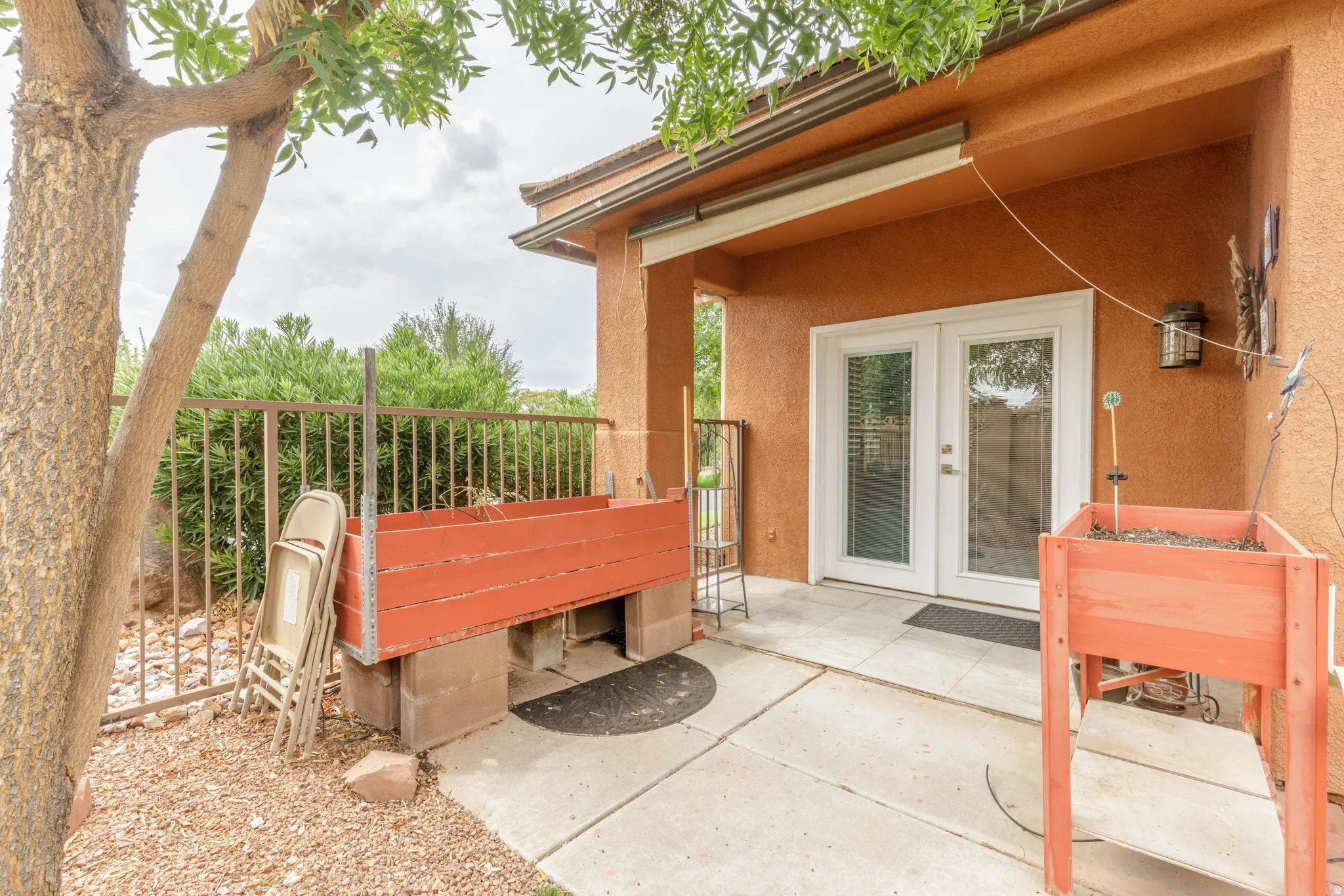 Patio area with concrete pavers, dual glass-paneled doors, and exterior lighting fixture