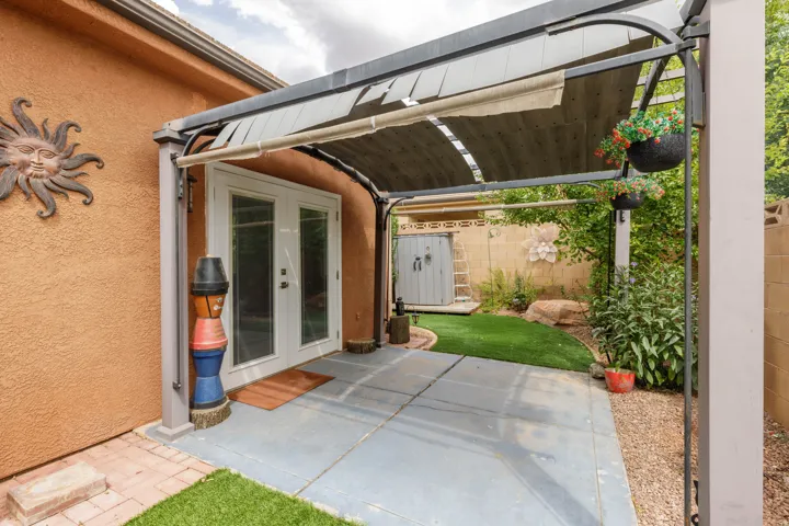 Covered patio with a retractable shade canopy and dual glass panel doors