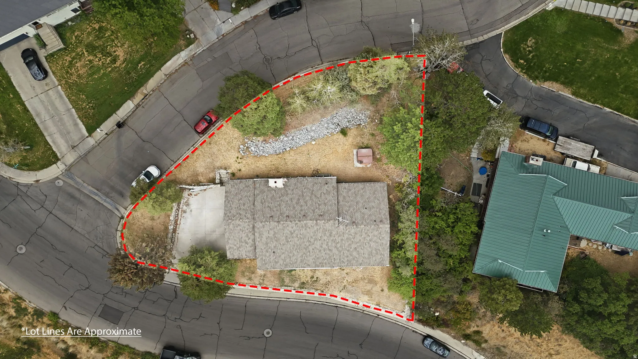 Property featuring a shingle roof, paved driveway, and mature landscaping