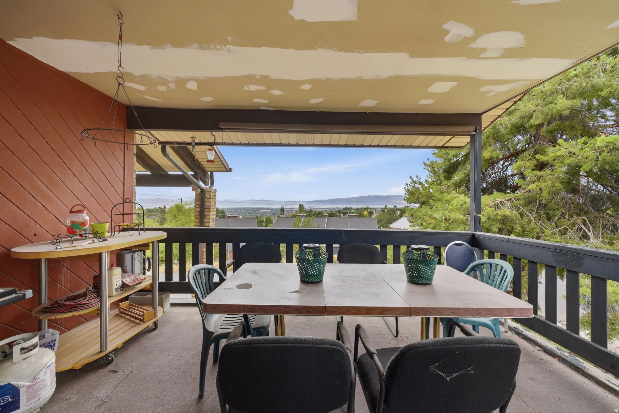 Covered outdoor patio with a plank-style wall and protective railing