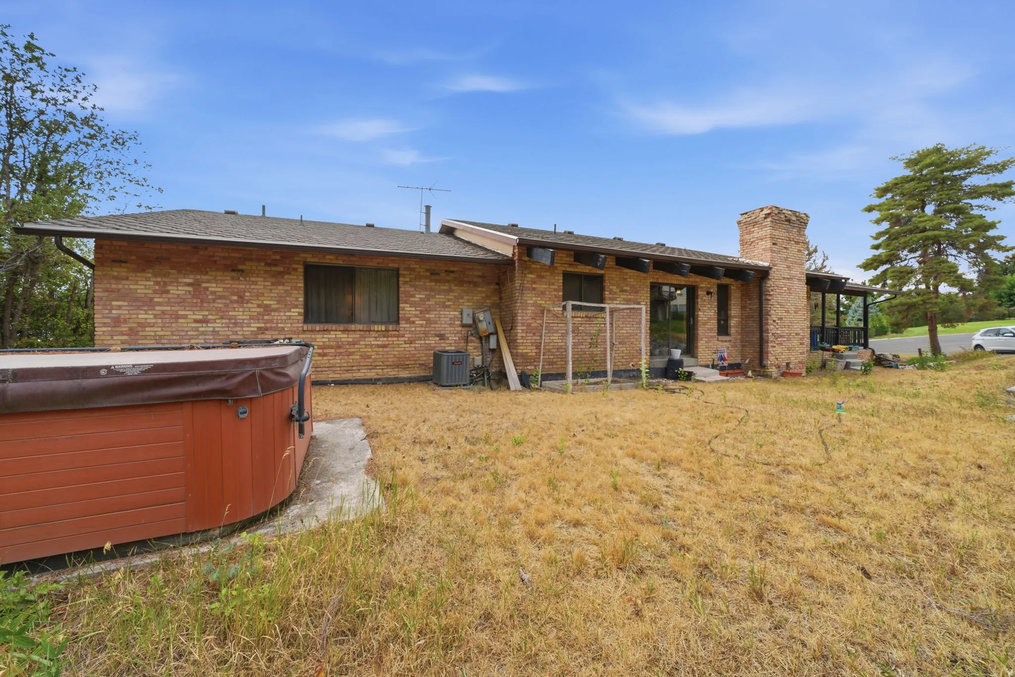 Brick exterior with a prominent brick chimney, and an attached outdoor spa