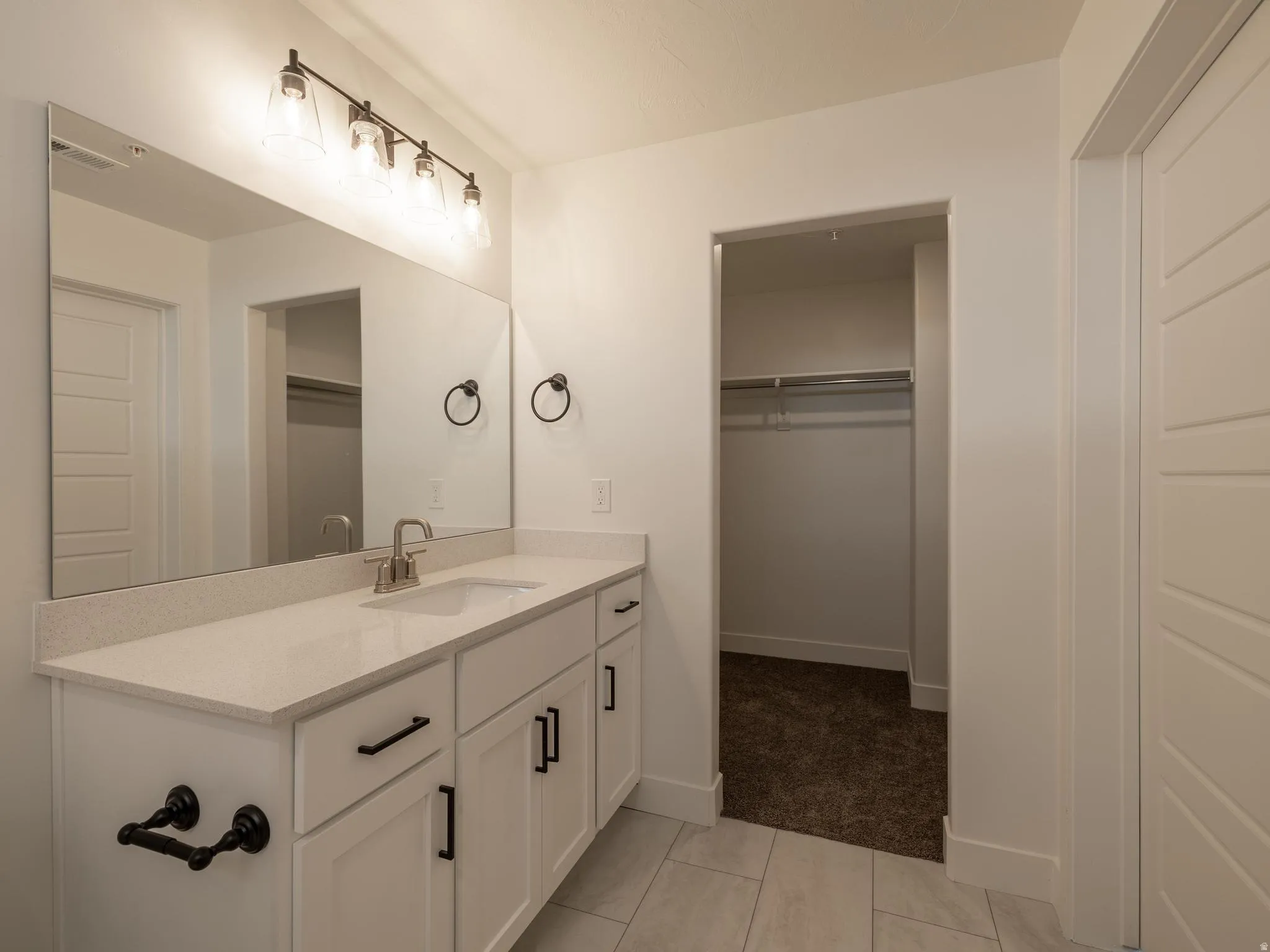 Spacious vanity with a white countertop, undermount sink, and brushed nickel faucet